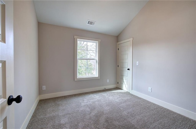 unfurnished room featuring lofted ceiling, baseboards, visible vents, and carpet