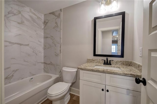 bathroom featuring baseboards, toilet, vanity, wood finished floors, and shower / bathtub combination