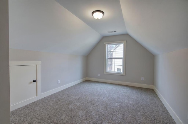 bonus room with carpet, visible vents, vaulted ceiling, and baseboards