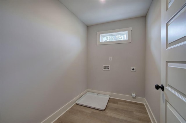 laundry room with electric dryer hookup, baseboards, and wood finished floors