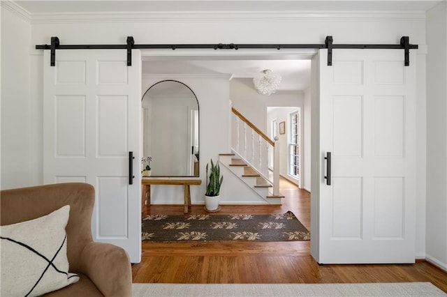 6960 Hunters Branch Dr, Atlanta, GA 30328 - foyer featuring a barn door, wood finished floors, stairs, and ornamental molding