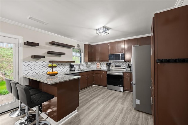 3208 Navajo Cir, Gainesville, GA 30501 - kitchen featuring stainless steel appliances, a peninsula, a sink, backsplash, and light wood-type flooring