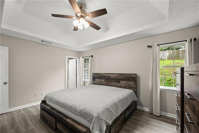 3208 Navajo Cir, Gainesville, GA 30501 - bedroom featuring a tray ceiling, wood finished floors, baseboards, and a ceiling fan