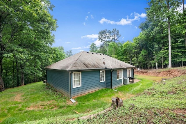 3208 Navajo Cir, Gainesville, GA 30501 - view of home's exterior featuring central AC unit, a yard, and roof with shingles