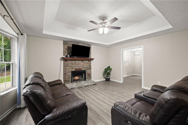 3208 Navajo Cir, Gainesville, GA 30501 - living room with a raised ceiling, baseboards, ceiling fan, wood finished floors, and a stone fireplace
