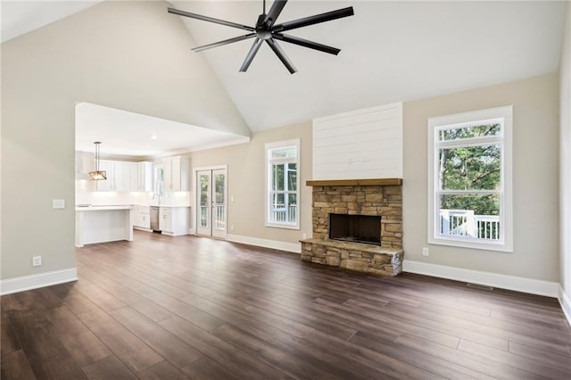 unfurnished living room with a fireplace, high vaulted ceiling, dark hardwood / wood-style floors, and ceiling fan