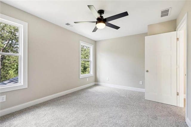 carpeted spare room with ceiling fan