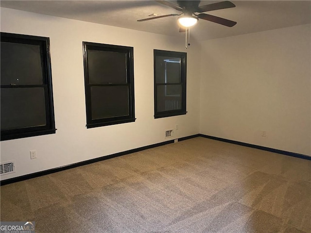 unfurnished room featuring a ceiling fan, carpet, visible vents, and baseboards