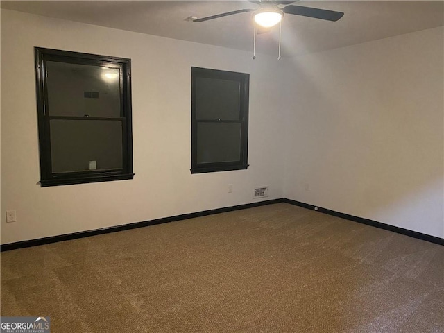 empty room with visible vents, ceiling fan, carpet flooring, and baseboards