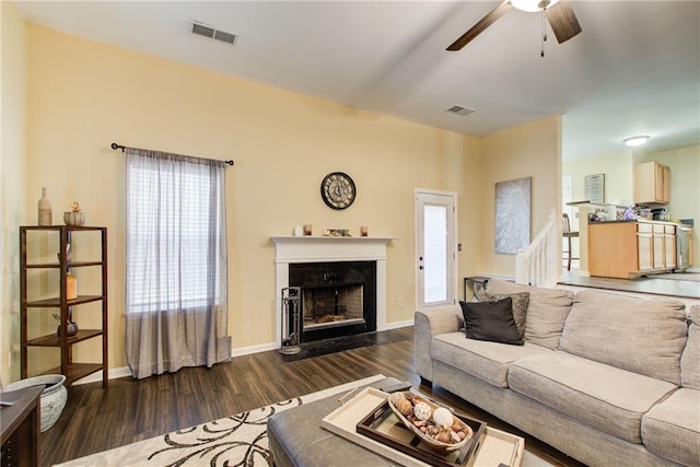 living room with ceiling fan and dark hardwood / wood-style flooring