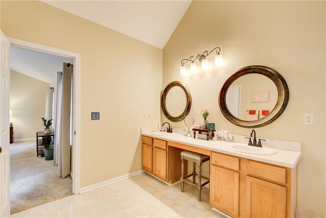 bathroom with tile patterned flooring, vanity, and vaulted ceiling