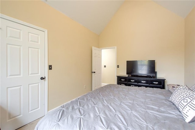 bedroom with light colored carpet and lofted ceiling