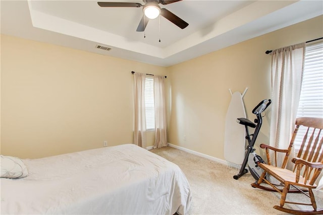 bedroom featuring a tray ceiling, ceiling fan, and light colored carpet