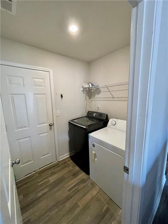 laundry area featuring dark hardwood / wood-style floors and washer and clothes dryer