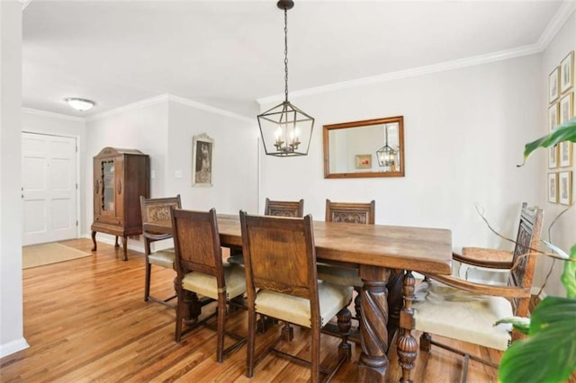 dining room with crown molding, a chandelier, and light hardwood / wood-style floors