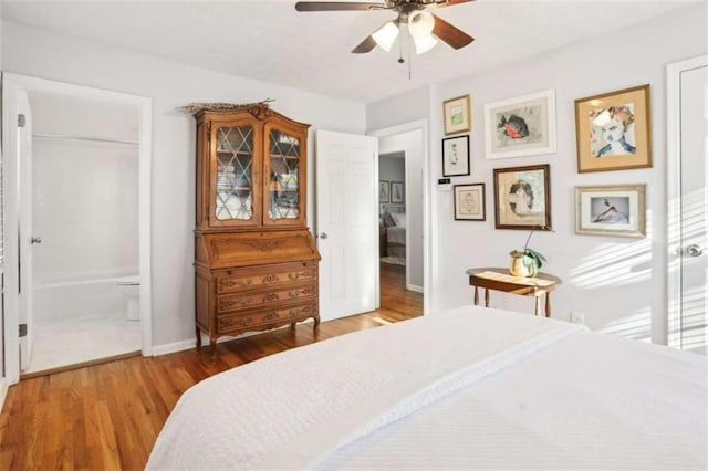 bedroom featuring wood-type flooring, ceiling fan, and ensuite bath