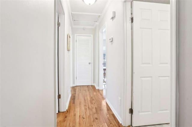 hall with ornamental molding and light hardwood / wood-style flooring