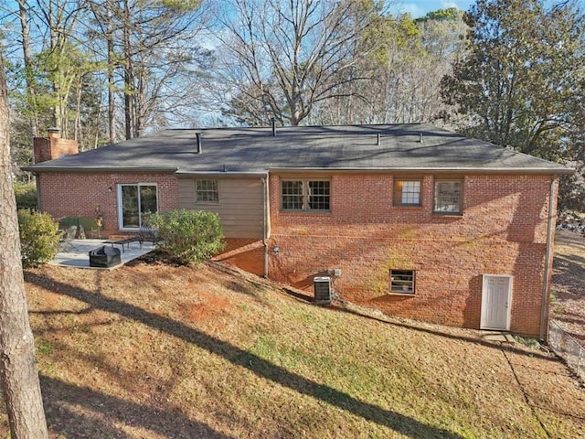 back of property with a yard and a patio