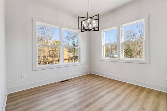 unfurnished dining area featuring crown molding, a notable chandelier, and a healthy amount of sunlight