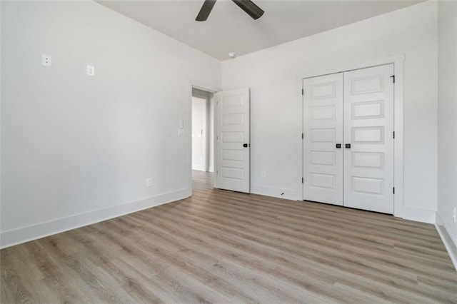 unfurnished bedroom featuring ceiling fan, light hardwood / wood-style floors, and a closet