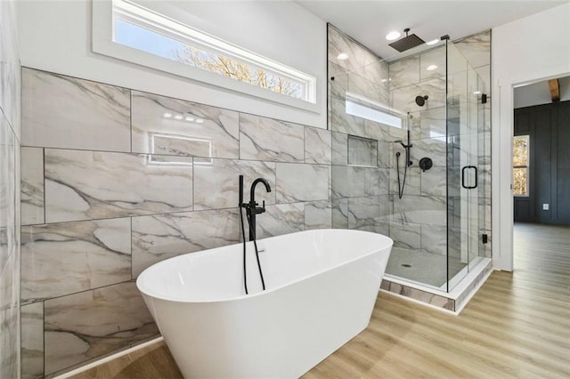 bathroom featuring separate shower and tub, a wealth of natural light, and wood-type flooring