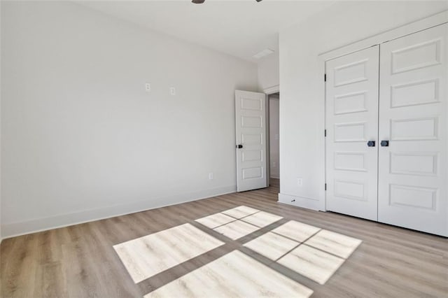 unfurnished bedroom with a closet and light hardwood / wood-style flooring