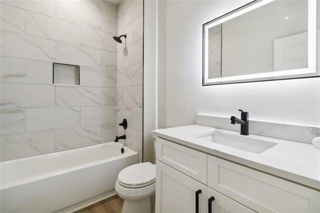 full bathroom featuring toilet, tiled shower / bath, hardwood / wood-style floors, and vanity