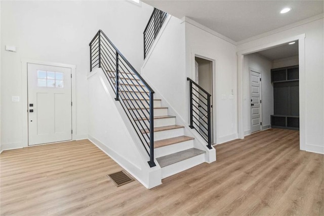 foyer entrance featuring light wood-type flooring and ornamental molding