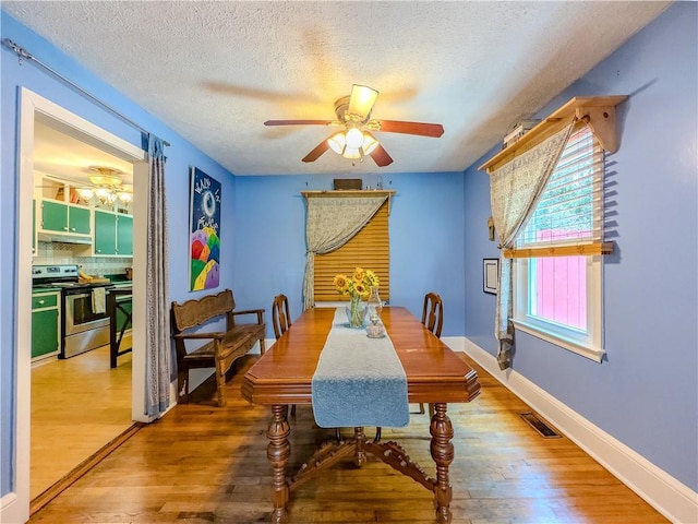 5130 Dearing St, Covington, GA 30014 - dining space with wood finished floors, ceiling fan, and a textured ceiling