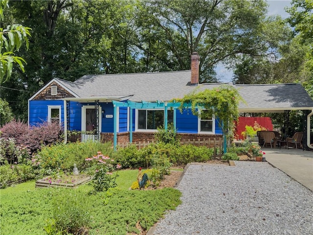 5130 Dearing St, Covington, GA 30014 - view of front facade featuring a chimney, brick siding, an attached carport, concrete driveway, and roof with shingles