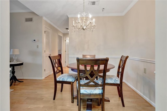 dining area featuring a notable chandelier, crown molding, and light hardwood / wood-style floors