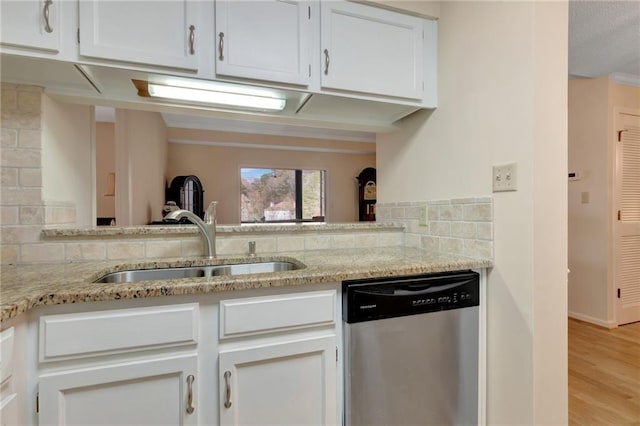 kitchen featuring light stone counters, stainless steel dishwasher, sink, and white cabinets