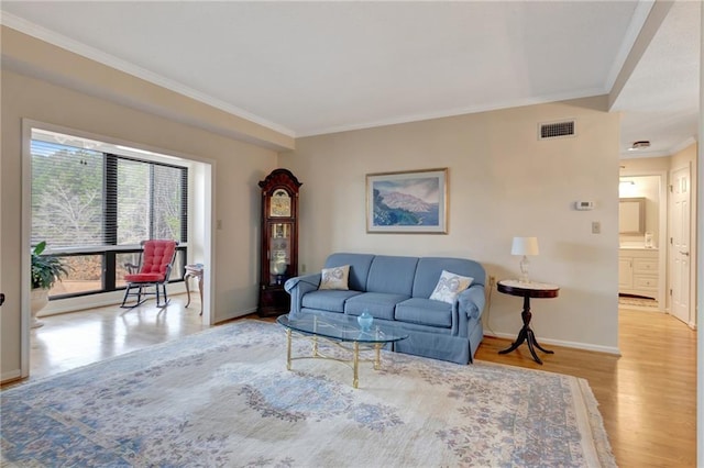 living room featuring ornamental molding and light hardwood / wood-style floors