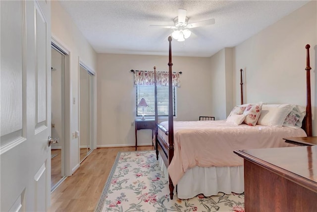 bedroom with a textured ceiling, ceiling fan, and light hardwood / wood-style floors