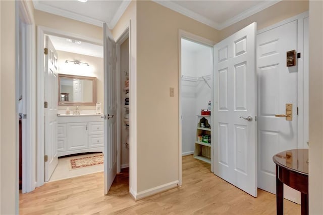 hall featuring ornamental molding, sink, and light hardwood / wood-style floors