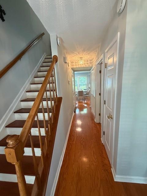 3545 Manchester Dr, Lawrenceville, GA 30044 - hall featuring wood finished floors, stairs, and a textured ceiling