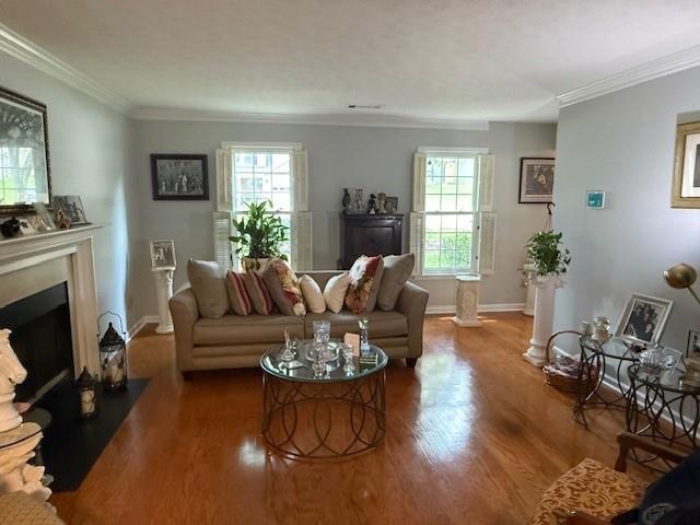 3545 Manchester Dr, Lawrenceville, GA 30044 - living room featuring plenty of natural light, a fireplace with flush hearth, crown molding, and wood finished floors