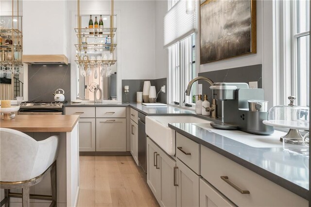 bedroom featuring ensuite bath, a chandelier, and light hardwood / wood-style floors