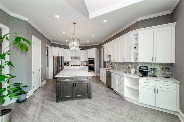 kitchen with light countertops, appliances with stainless steel finishes, a kitchen island, and open shelves