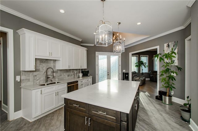 kitchen with a kitchen island, decorative light fixtures, sink, white cabinets, and dark brown cabinets