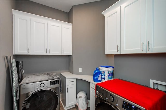 laundry room featuring separate washer and dryer and cabinets