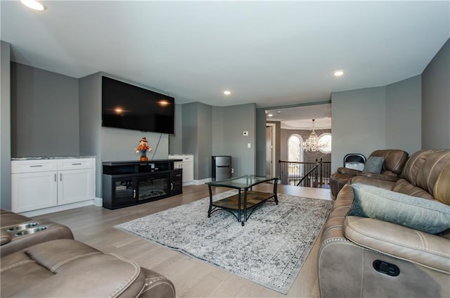 living area with a chandelier, light wood-type flooring, and recessed lighting