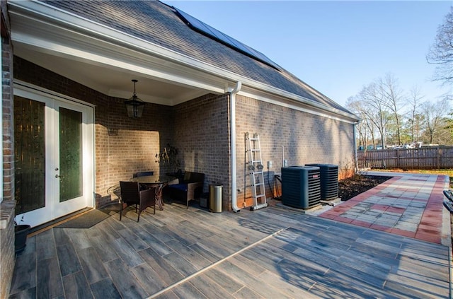 wooden terrace featuring french doors, cooling unit, fence, and a ceiling fan