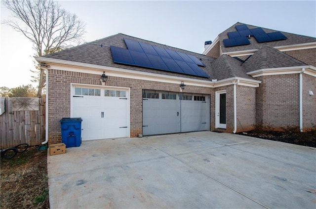 exterior space with driveway, fence, and solar panels