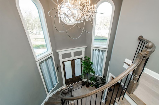 entryway featuring stairs, wood finished floors, a wealth of natural light, and baseboards