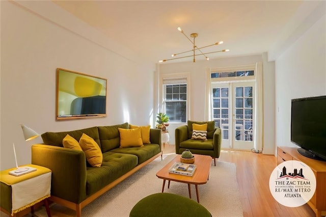 living room featuring hardwood / wood-style flooring, a notable chandelier, and french doors