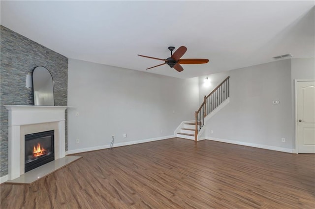 unfurnished living room with hardwood / wood-style flooring, ceiling fan, and a premium fireplace