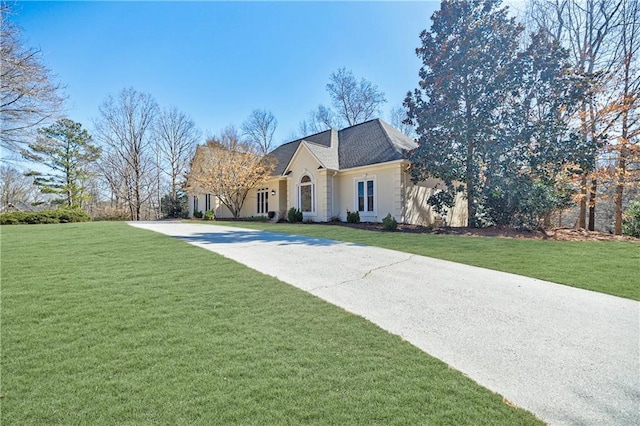 french provincial home with driveway and a front lawn