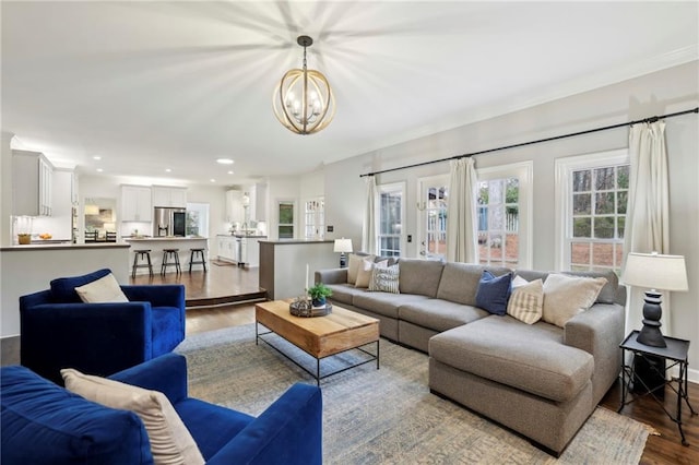 living room with recessed lighting, crown molding, an inviting chandelier, and wood finished floors