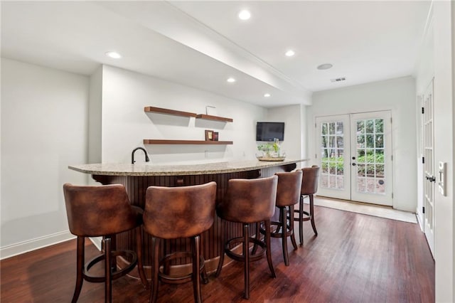 bar featuring dark wood-style floors, recessed lighting, wet bar, and french doors